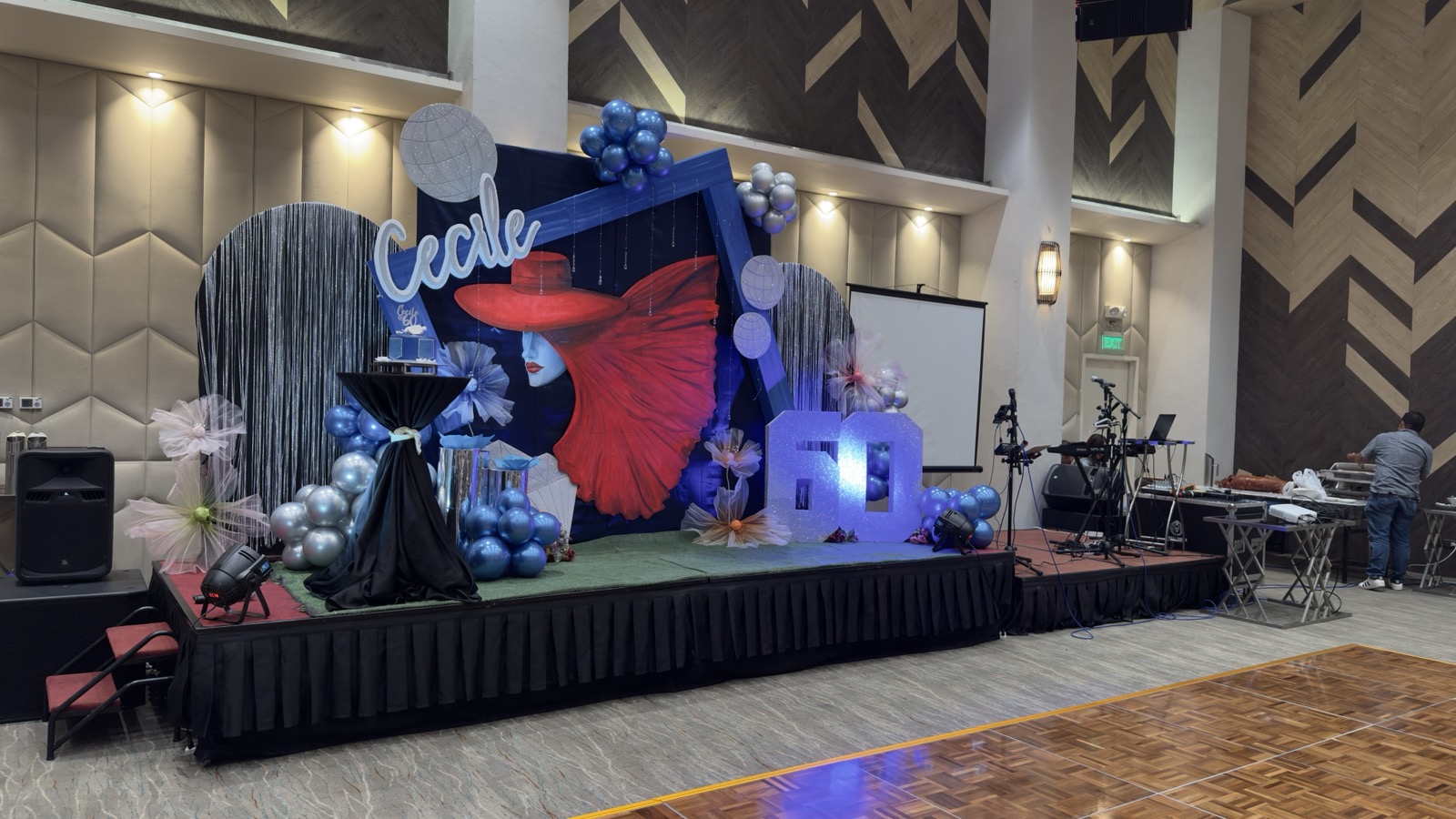 Elegant event setup by Ces — stage backdrop with blue and silver balloon arch at Cecile's 60th birthday celebration